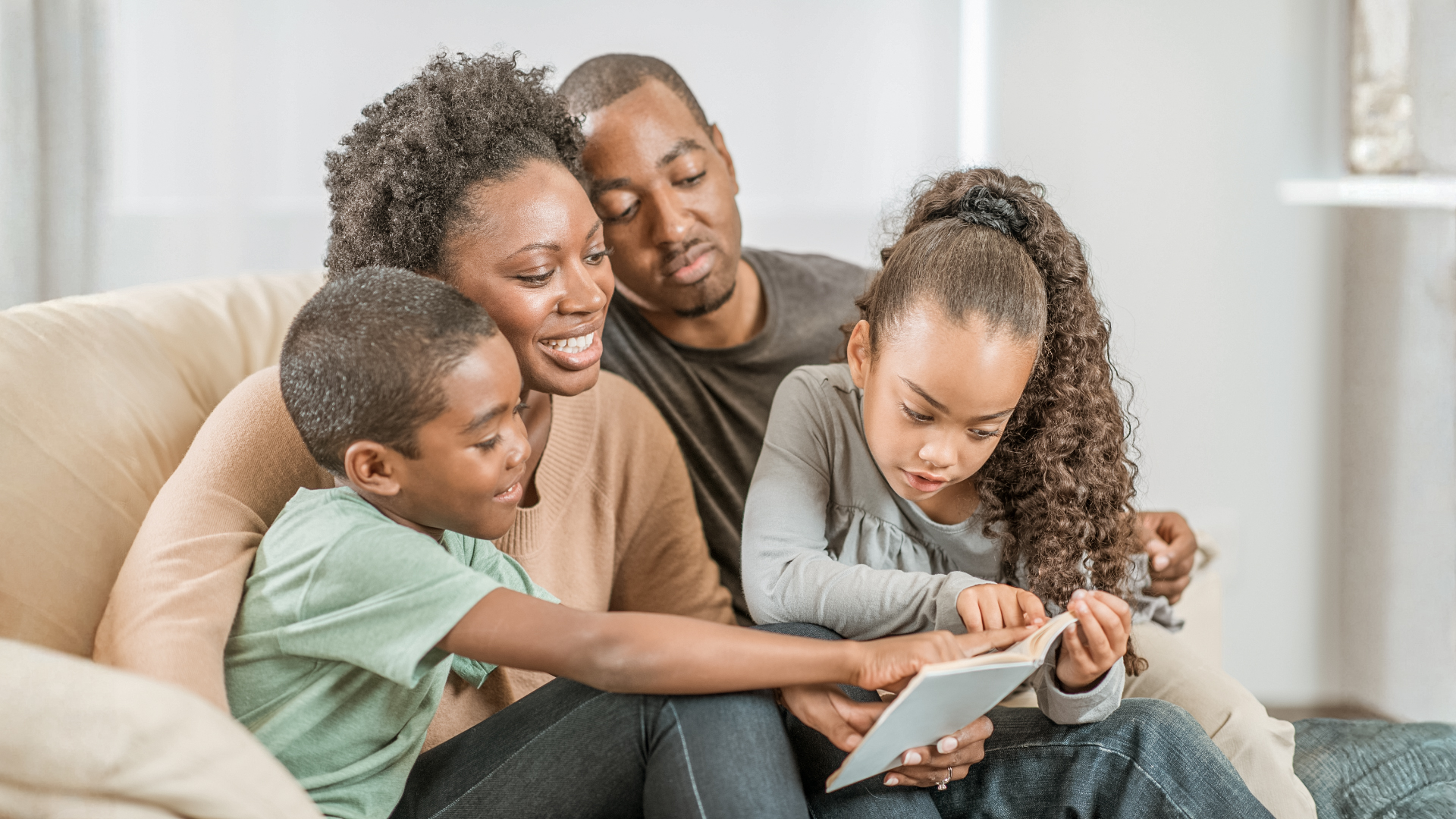 A family reading together on the couch at home